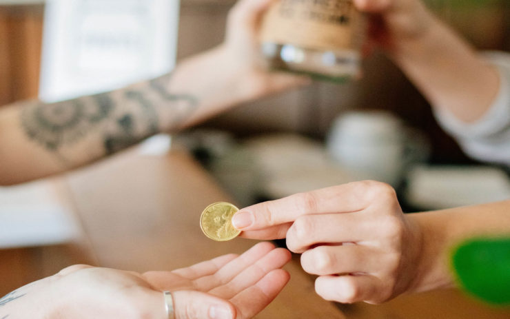 A customer shown hands only returning a pint jar in exchange for a loonie