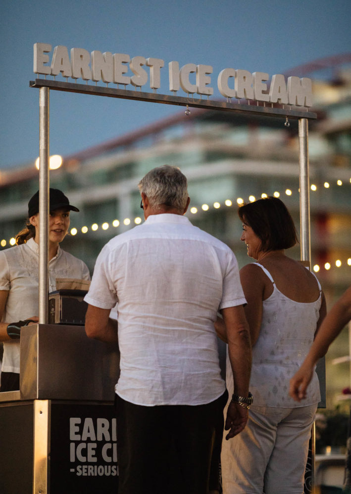 Man and woman stand in front of an ice cream stand serving ice cream at a Vancouver event.