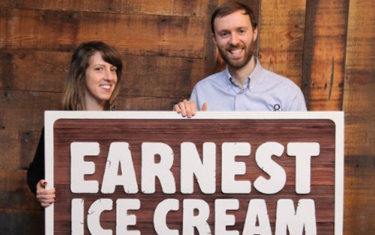Erica and Ben holding a wooden sign when they first started Earnest Ice Cream